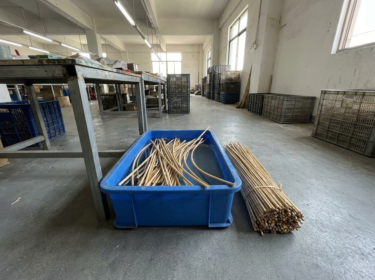 Brins de rotin en train de tremper dans un bac d'eau à l'atelier